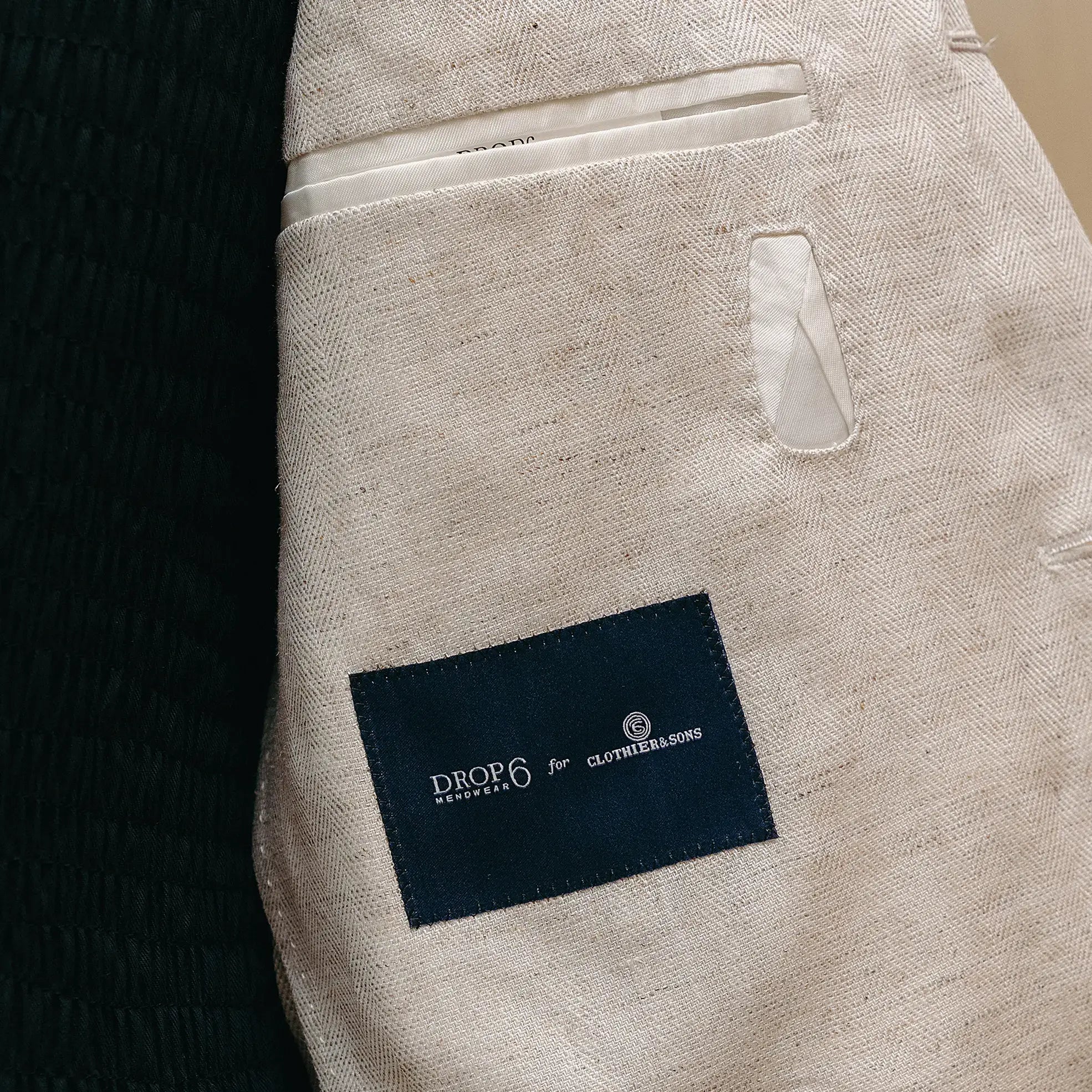 Fabric detail of the Drop6 Linen Tencel Herringbone Suit Ivory revealing the herringbone weave, linen-tencel blend texture, and natural ivory color for Clothier & Sons.