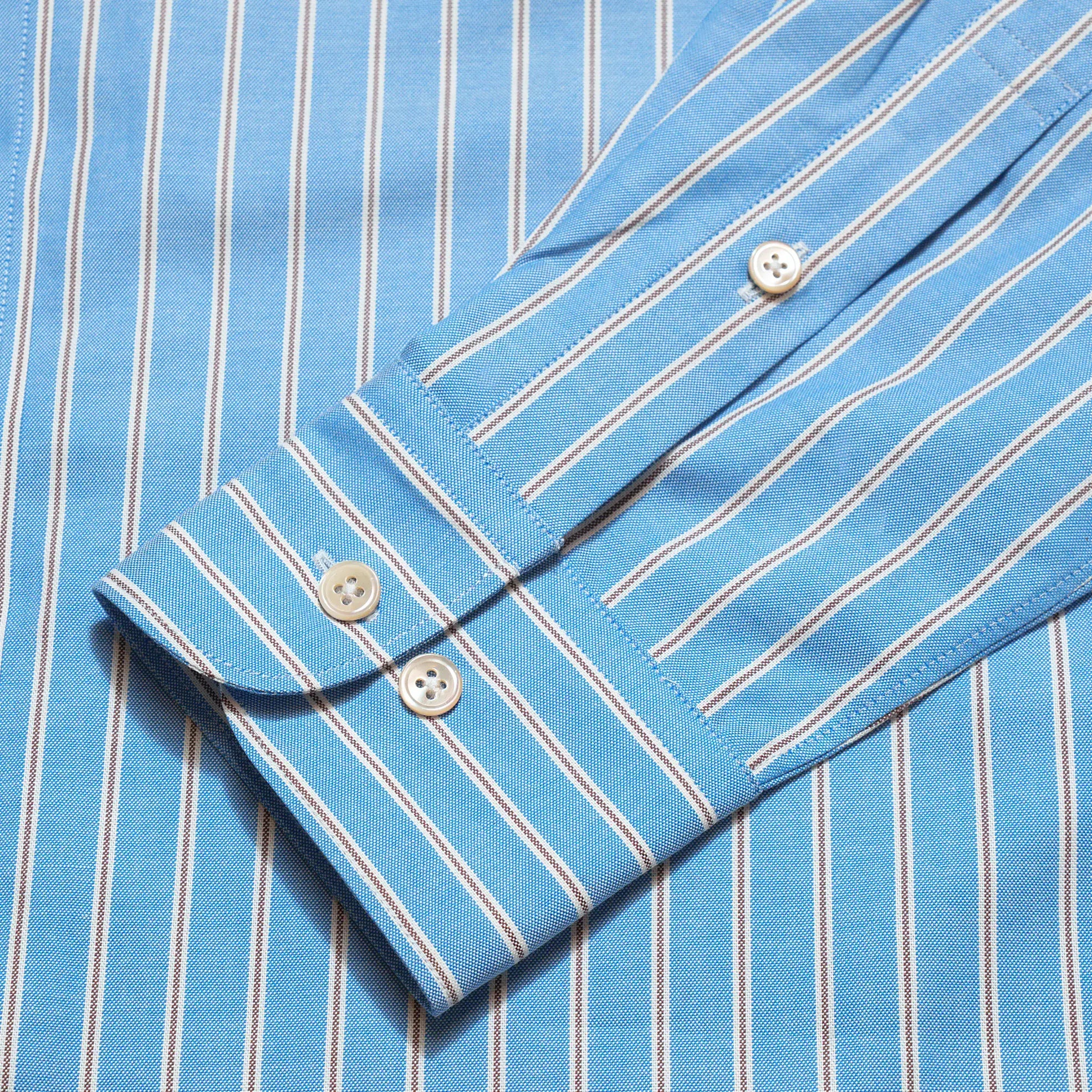 Cuff detail of the Drop6 New Bold Stripe Button Down Shirt Blue showing sleeve placket construction and button fastening for Clothier & Sons.