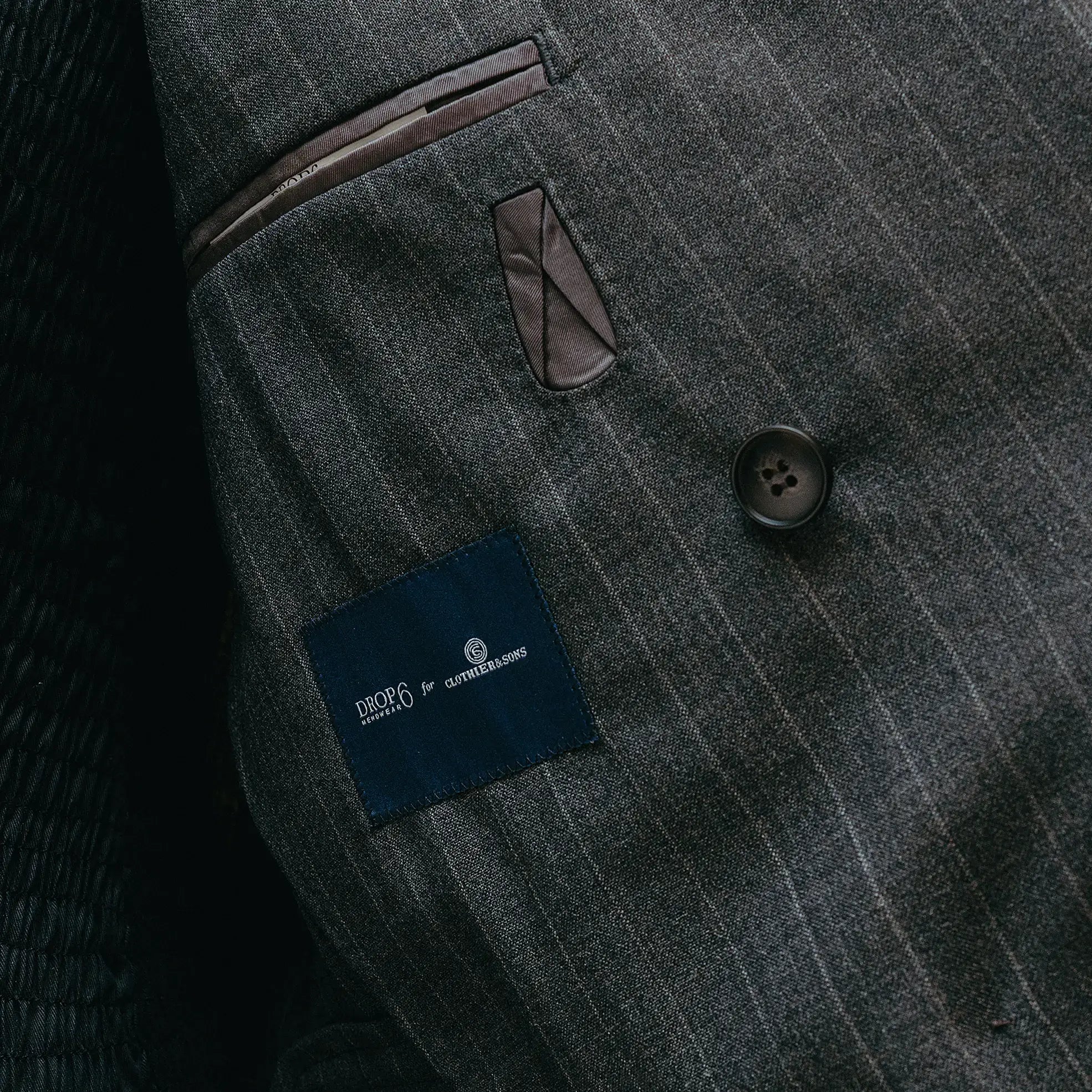 Lapel detail of the Drop6 Wool Chalk Stripe Double Breasted Suit Charcoal Grey highlighting peak lapel shape, chalk stripe pattern, and clean finishing for Clothier & Sons.