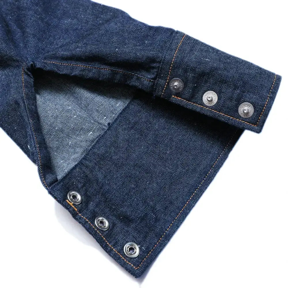 Cuff button detail of the Jelado Vaquero Shirt Indigo showing sleeve placket construction, button hardware, and western-style stitching for Clothier & Sons.
