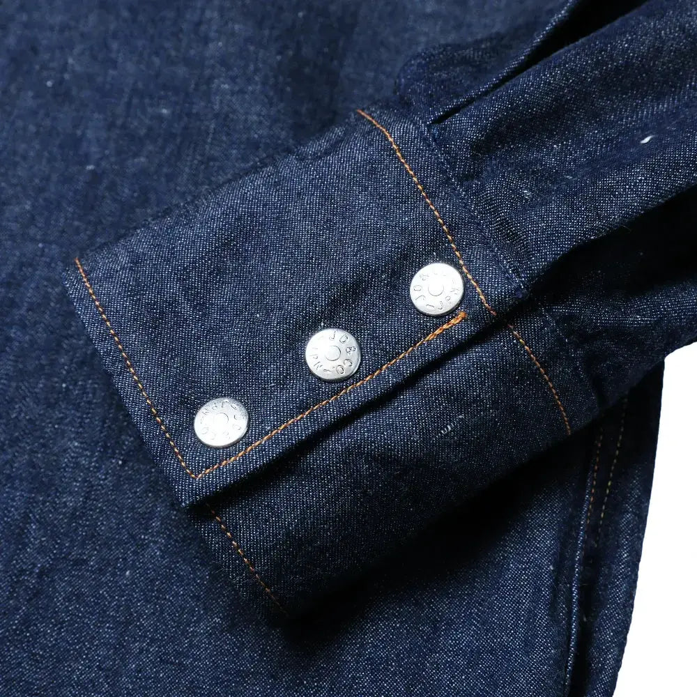 Cuff button detail of the Jelado Vaquero Shirt Indigo showing sleeve placket construction, button hardware, and western-style stitching for Clothier & Sons.
