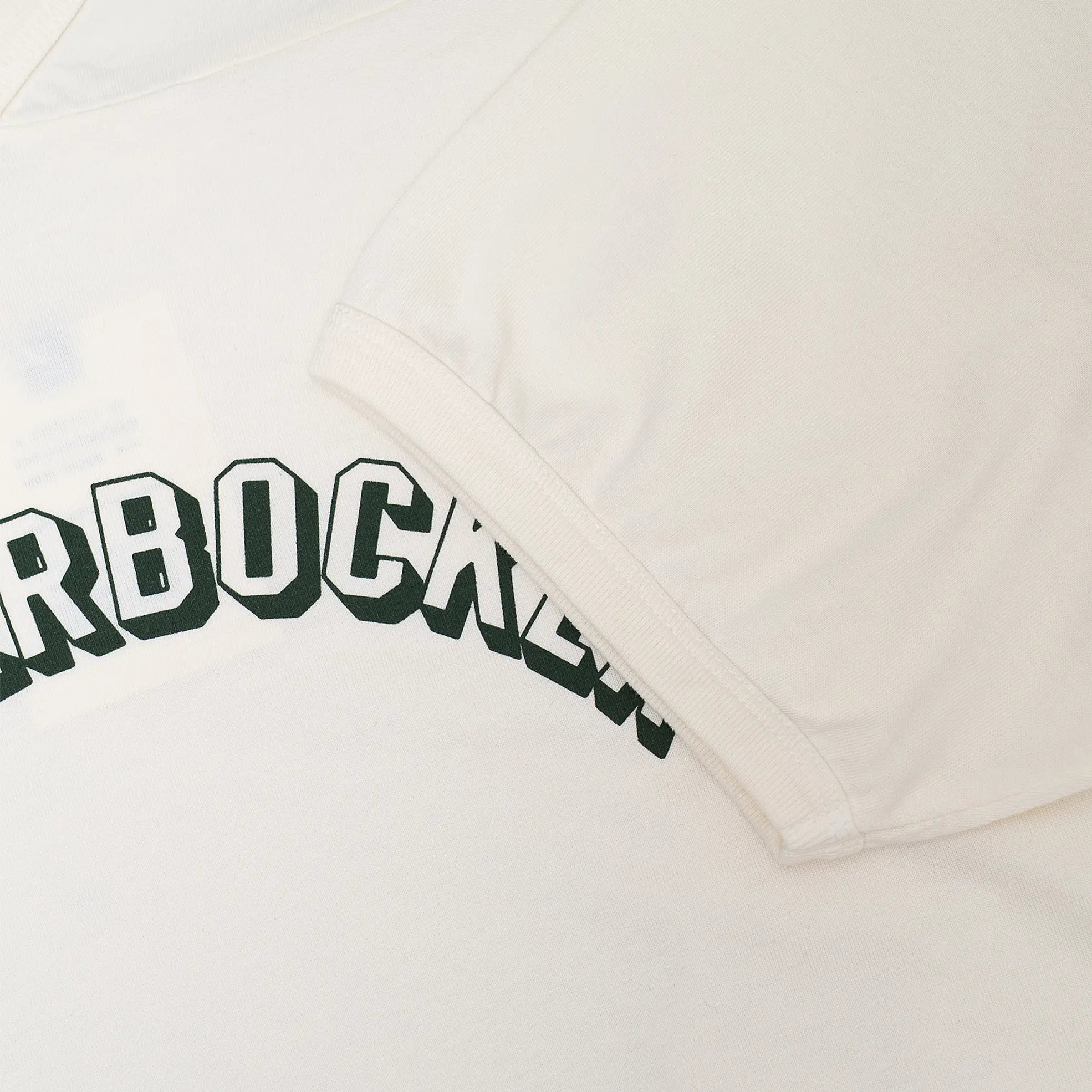 Fabric detail of the Knickerbocker Track Tee Milk revealing cotton jersey texture, soft hand feel, and smooth milk color tone for Clothier & Sons.