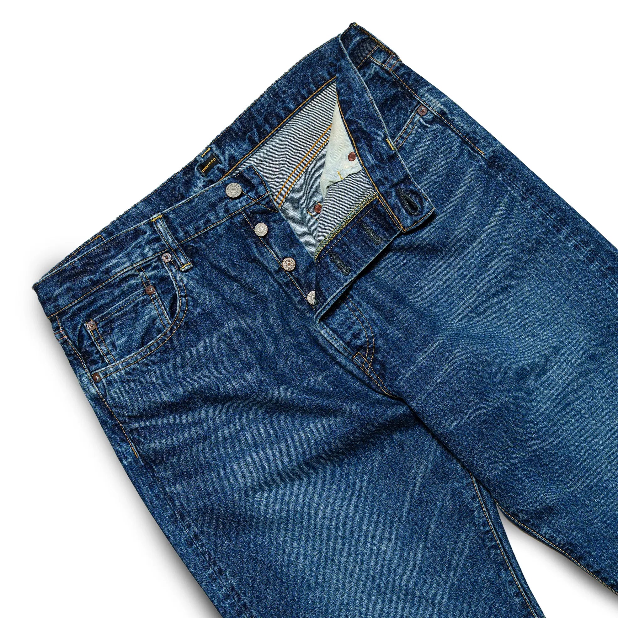 Fabric detail of the Omnigod Clothier & Sons Selvedge Used Wash Jeans revealing selvedge denim texture, worn-in wash effects, and depth of indigo tone for Clothier & Sons.