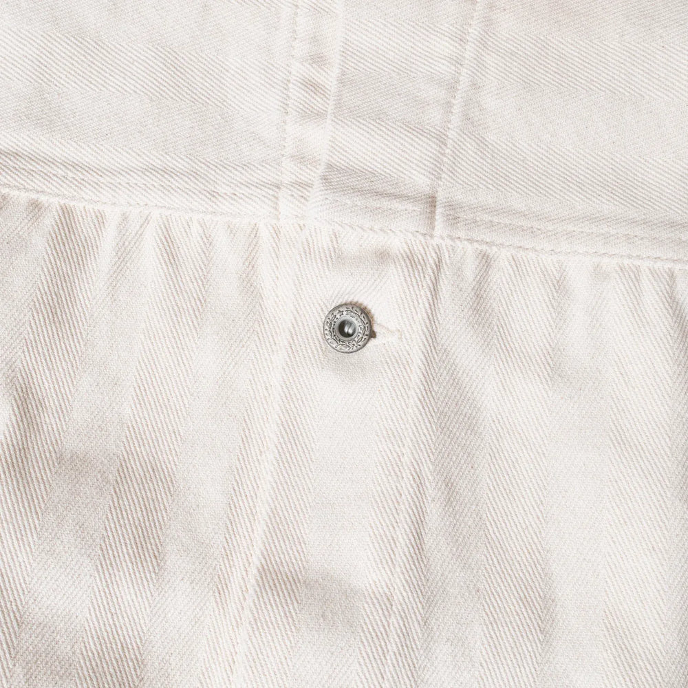 Close-up of metal button fastening on Seuvas Herringbone Trucker Jacket in natural.
