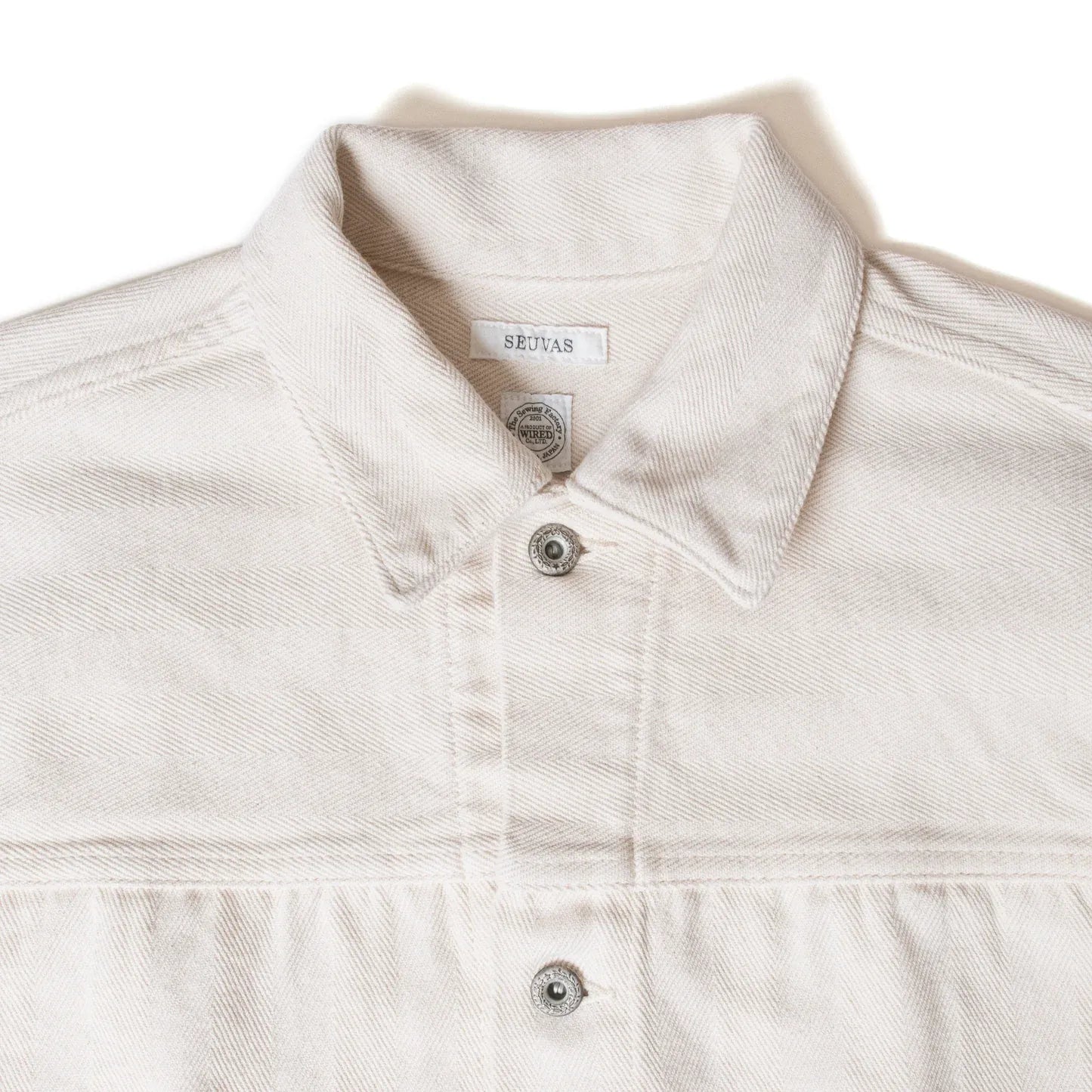 Close-up of pointed collar and stitching detail on Seuvas Herringbone Trucker Jacket in natural.