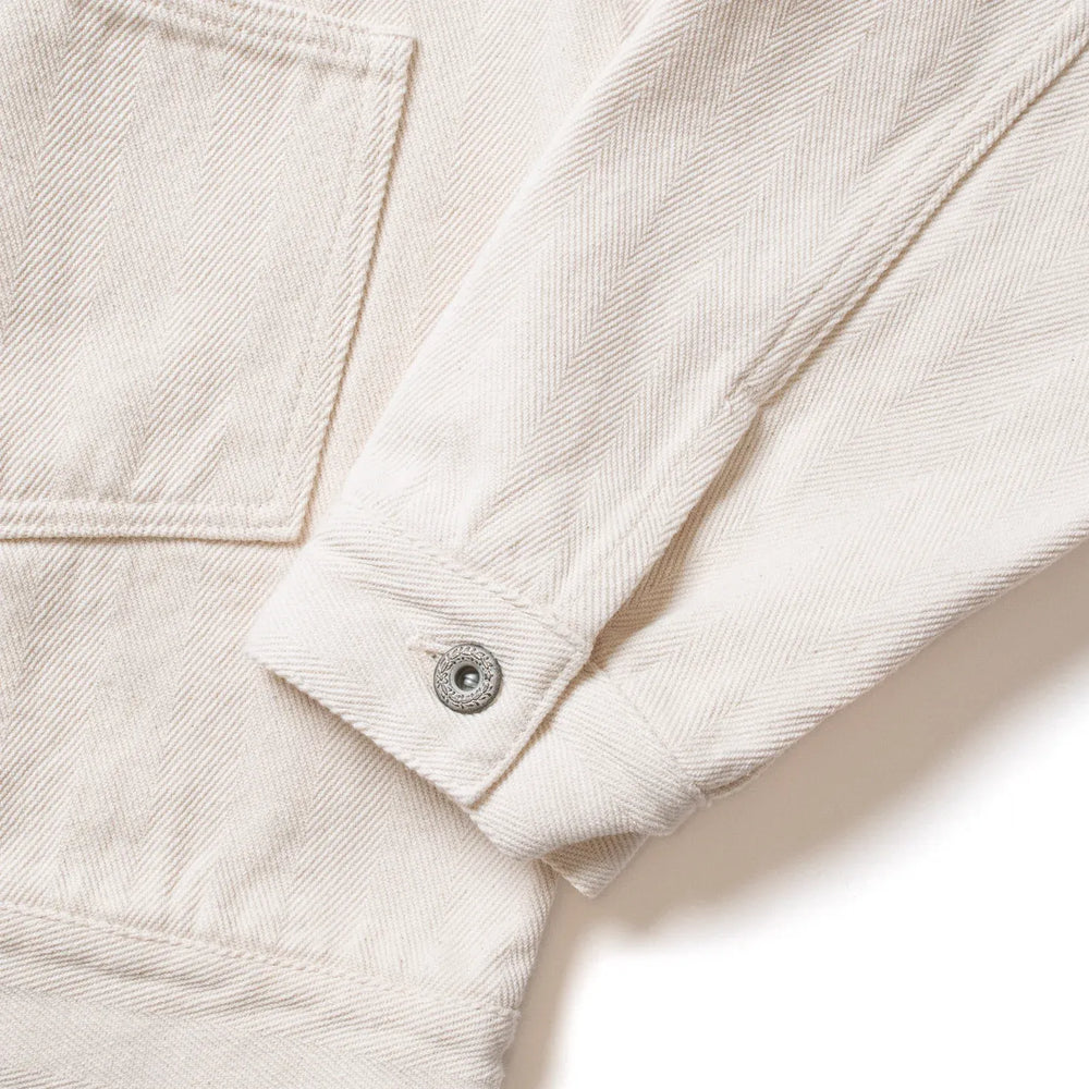 Close-up of sleeve seam and cuff construction on Seuvas Herringbone Trucker Jacket in natural.