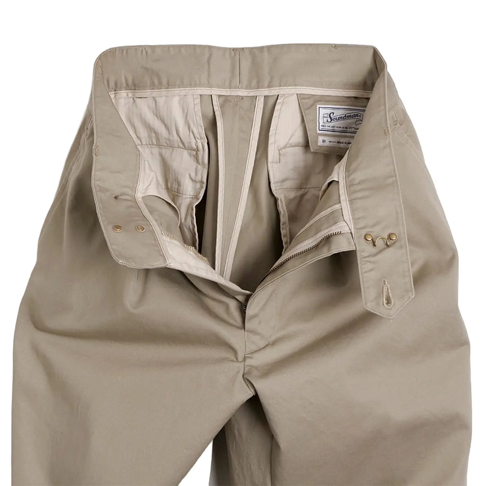 Close-up of the waistband highlighting button closure and belt loop construction.
