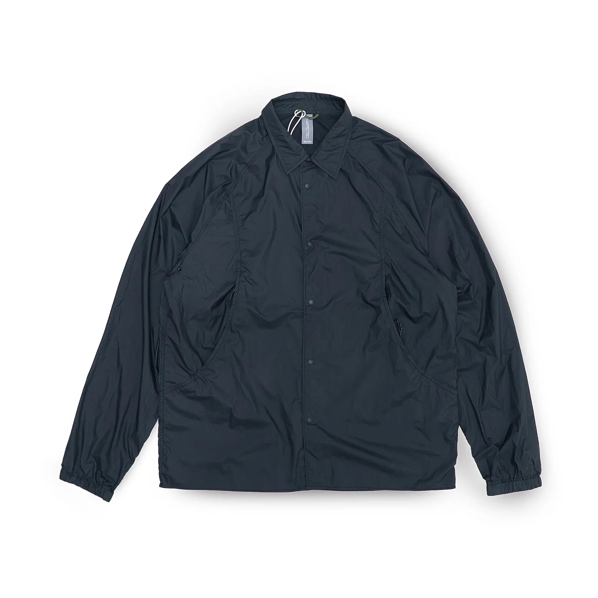 Front view of the Unaffected Blouson Track Shirt Black showing the blouson silhouette, clean black tone, and minimal contemporary design for Clothier & Sons.
