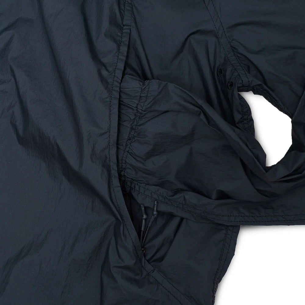 Side view of the Unaffected Blouson Track Shirt Black showing sleeve volume, hem shape, and balanced blouson profile for Clothier & Sons.