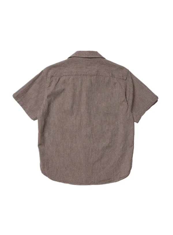 A close-up view of the JELADO Mechanic Shirt in a white cypress color, showcasing the textured cotton chambray fabric, open-collar design, and subtle puckering around the shoulder, reflecting a vintage 1930s-1940s work shirt style.